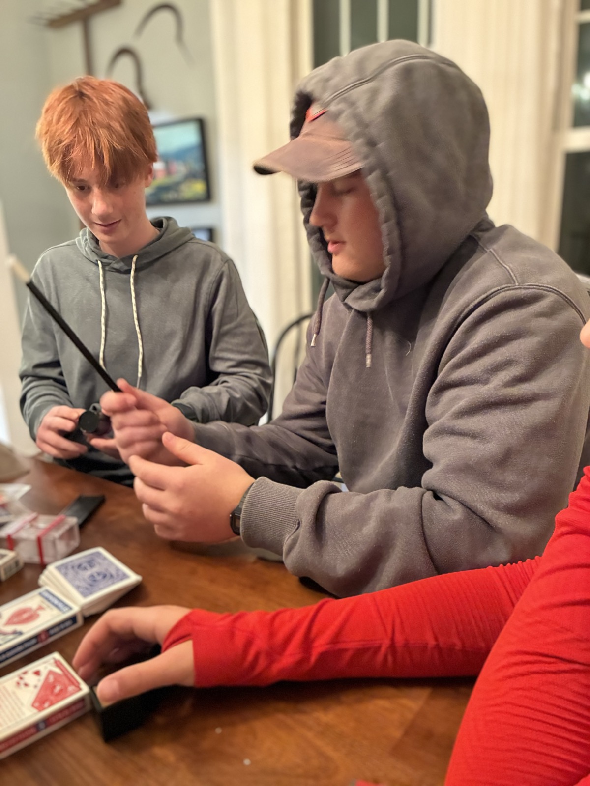Cousins practicing magic tricks with multiple decks of cards